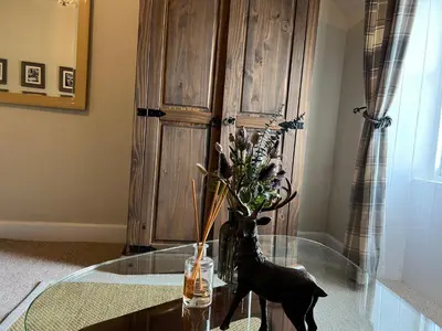 a glass table with a statue of a deer on it at Chefs cottage in Kenmore