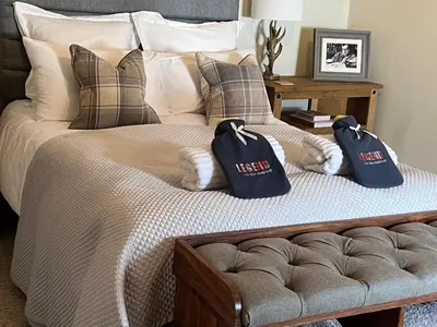 a bedroom with a bed with two bags on it at Chefs cottage in Kenmore