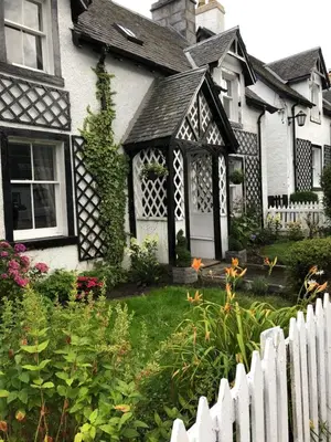 a white fence in front of a house at Chefs cottage in Kenmore