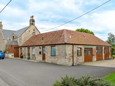 an old stone building with a rusty roof at The Cottage At Cauldcoats in Linlithgow