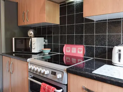 a kitchen with a stove and a microwave at Tree Tops in Crieff