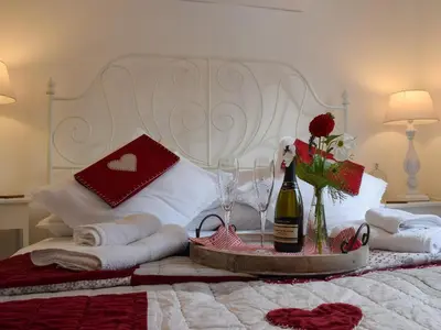 a bed with a bottle of wine and flowers on it at Tree Tops in Crieff