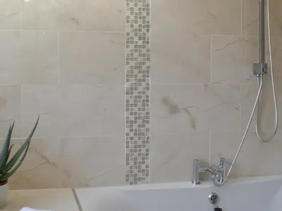 a bathroom with a shower with a bath tub at The Calving Shed in Neilston