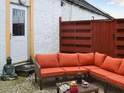 a couch sitting on a patio next to a door at The Calving Shed in Neilston
