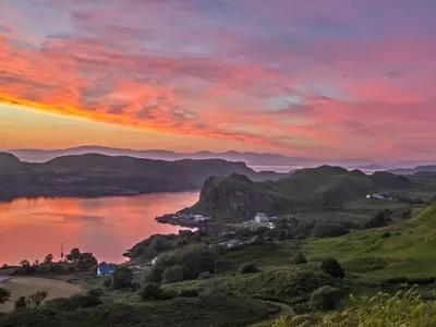 a sunset over a body of water with mountains at Puffin - Dubh Segir in Lerags