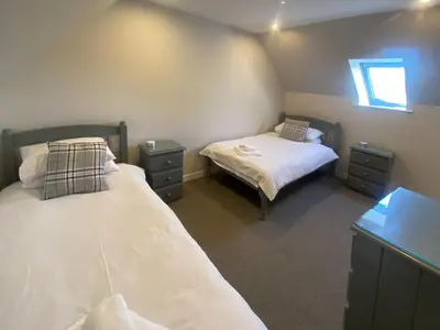 a bedroom with two beds and two night stands at Puffin - Dubh Segir in Lerags