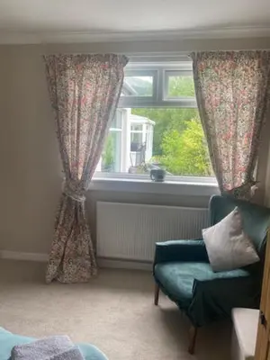 a living room with a chair and a window at Sir Andrew Murray House in Strathyre