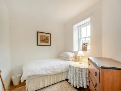 a bedroom with a bed and a dresser and a window at Inverglen Farm in Strachur