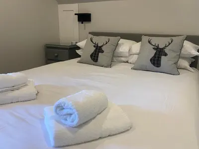 a white bed with towels on top of it at Puffin - Bach in Lerags