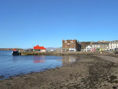 a view of a beach with buildings in the background at Puffin - Bach in Lerags