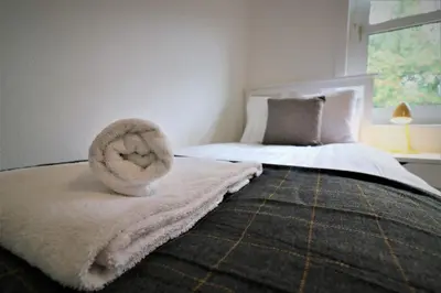 a bedroom with a bed with a towel on it at Signature - Shawburn House in Hamilton