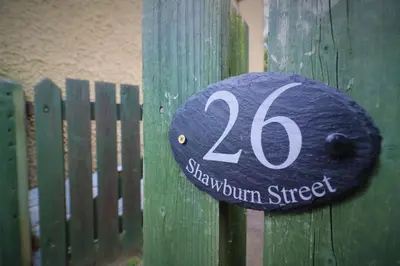 a sign on a wooden fence with the number on it at Signature - Shawburn House in Hamilton