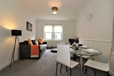 a living room with a couch and a table at Signature - Shawburn House in Hamilton