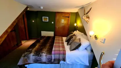 a bed in a room with green walls at The Coylet Inn by Loch Eck in Dunoon