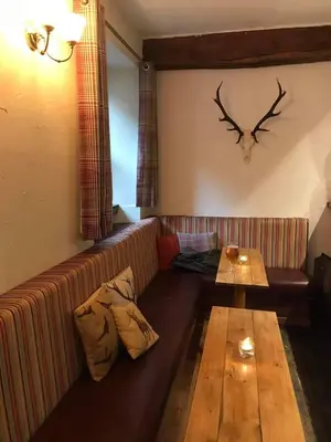 a living room with a couch and a wooden table at The Coylet Inn by Loch Eck in Dunoon