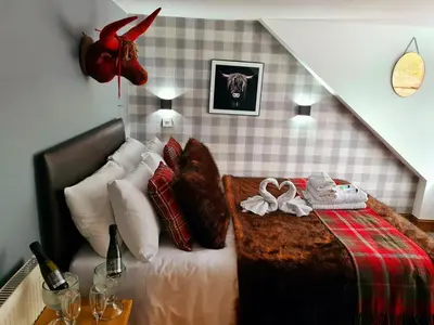 a bedroom with a bed with a deer head on the wall at The Coylet Inn by Loch Eck in Dunoon