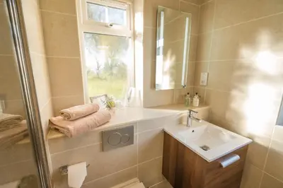 a bathroom with a sink and a mirror at Dunroamin in Drymen
