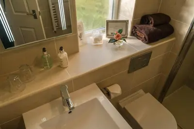 a bathroom with a sink and a toilet and a mirror at Dunroamin in Drymen