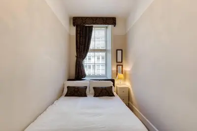 a small bedroom with a bed and a window at West Port - 2BR in the heart of the old town just off the Grassmarket in Edinburgh