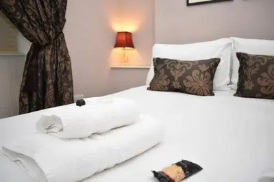 a hotel room with a white towel on a bed at West Port - 2BR in the heart of the old town just off the Grassmarket in Edinburgh