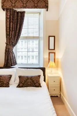 a bedroom with a white bed and a window at West Port - 2BR in the heart of the old town just off the Grassmarket in Edinburgh