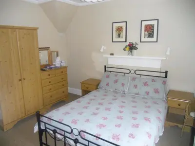 a bedroom with a bed and a dresser at Ormidale Hotel in Brodick