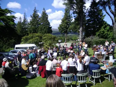 a crowd of people standing around in the grass at Ormidale Hotel in Brodick