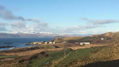 a town on a hill next to a body of water at Number 10, Isle of Luing in Cullipool