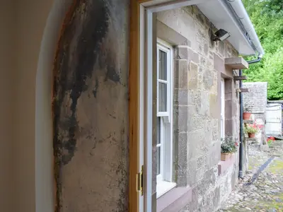 an open door to a stone house with a window at The Old Stables At Westerton in Crieff
