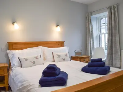 a bedroom with a bed with blue towels on it at The Old Stables At Westerton in Crieff