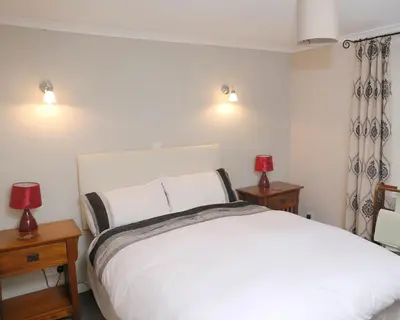 a bedroom with a large white bed with two lamps at The Dunning Hotel in Perth