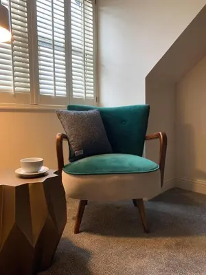 a green chair in a room with a table at The Balerno Inn in Edinburgh