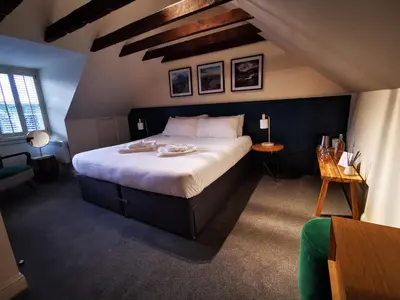 a bedroom with a large bed in a attic at The Balerno Inn in Edinburgh