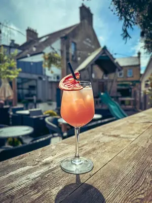 a drink in a glass sitting on a wooden table at The Balerno Inn in Edinburgh