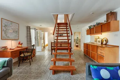 a living room with a wooden ladder in a room at Enchanting,rustic, Dundurn Mill with stunning views and private river in Comrie