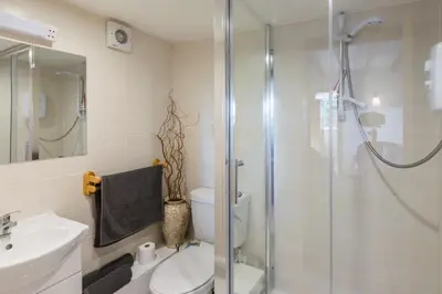 a bathroom with a shower and a toilet and a sink at Altquhur Byre in Drymen