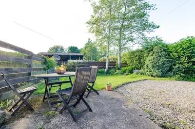 a table and two chairs in a backyard at Altquhur Byre in Drymen