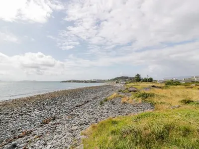 a rocky beach with the ocean in the background at Grebe Cottage in Oban