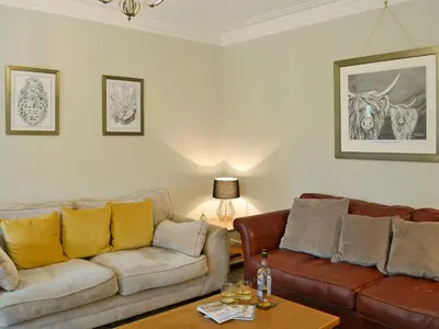 a living room with two couches and a table at Altbeg in Brodick
