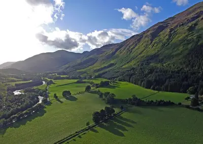 an aerial view of a green valley in the mountains at Gardeners Cottage in Chesthill