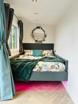 a bedroom with a bed with a mirror on the wall at Hazells Lodge Farm Stay Sleeps 2 Undercover Hottub and Pool Table in Galston
