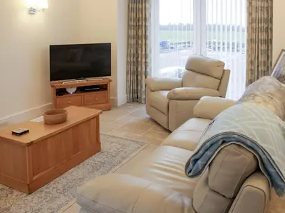 a living room with a couch and a television at Rhunahaorine Cottage in Gortinanane