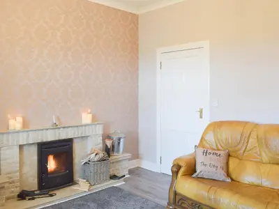 a living room with a couch and a fireplace at Ardlochan Cottage in Maidens