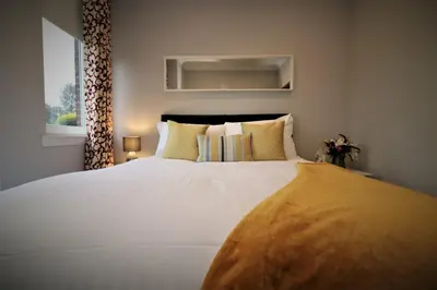 a bedroom with a large white bed and a window at Signature - Greenlees Clubhouse 3 Bed in Cambuslang