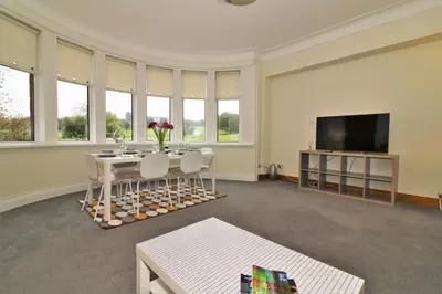 a living room with a table and a flat screen tv at Signature - Greenlees Clubhouse 3 Bed in Cambuslang