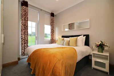 a bedroom with a large bed and a large window at Signature - Greenlees Clubhouse 3 Bed in Cambuslang