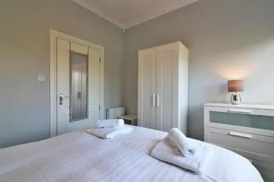 a bedroom with a bed with two towels on it at Signature - Greenlees Clubhouse in Glasgow
