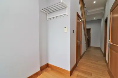 a hallway with white walls and wooden floors at Signature - Greenlees Clubhouse in Glasgow