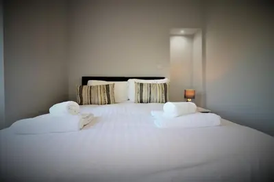 a large white bed with towels on top of it at Signature - Greenlees Clubhouse in Glasgow