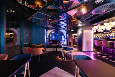 a room with tables and chairs and a bar at YOTEL Glasgow in Glasgow